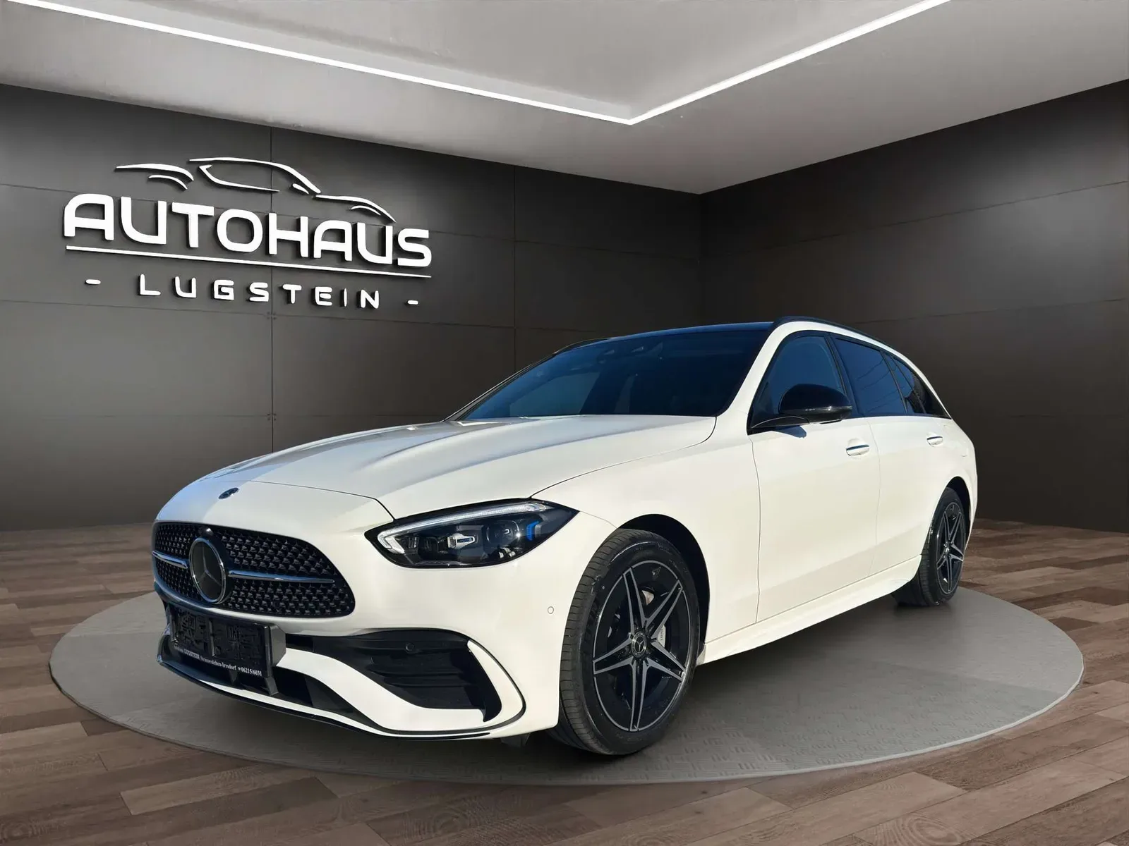 Weißes Mercedes-Benz C-Klasse T-Modell AMG Line schräg von vorne im Schauraum des Autohauses Lugstein in Straßwalchen