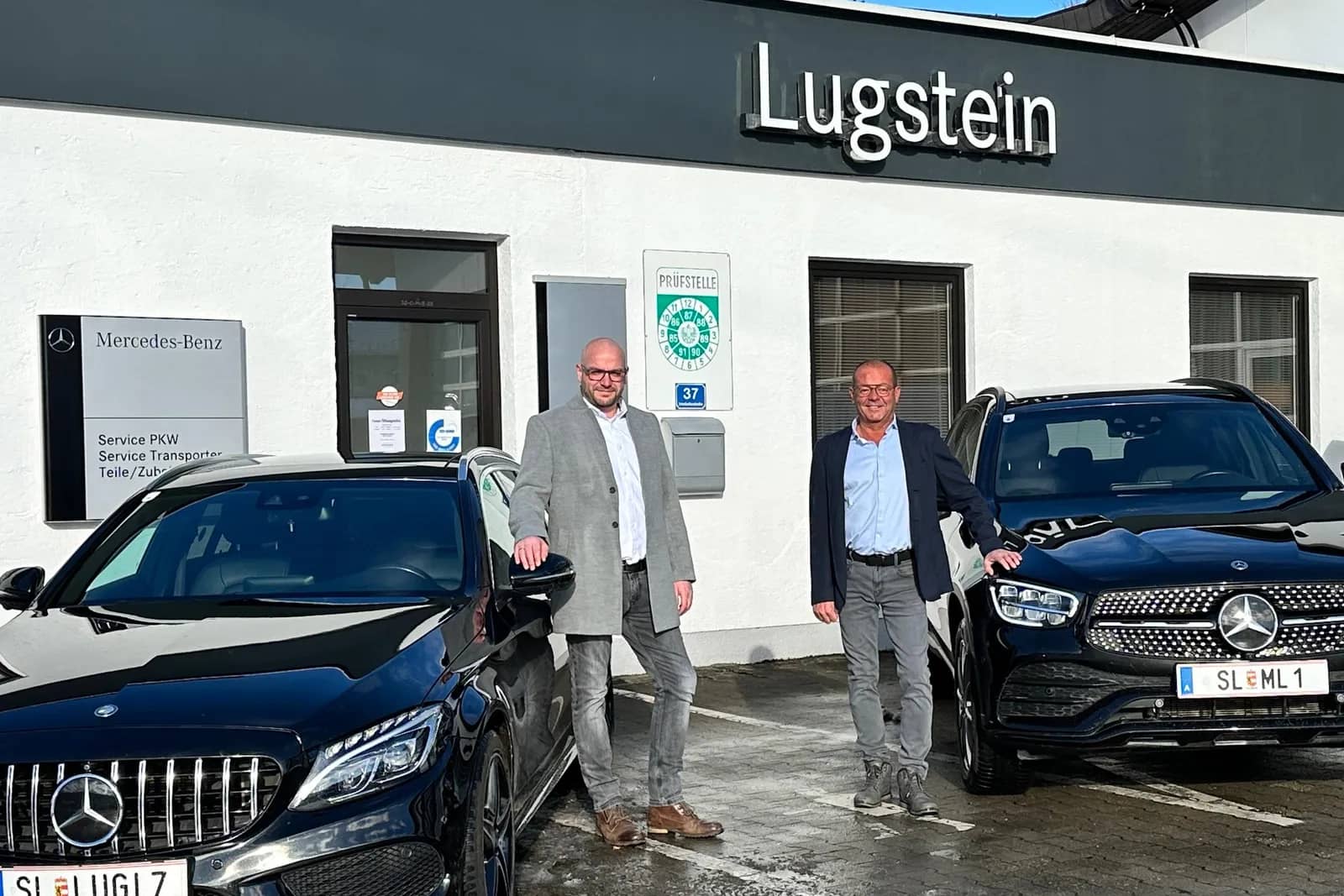 Daniel und Manfred Lugstein vor dem Autohaus Lugstein in Straßwalchen, daneben ein Mercedes-AMG und ein Mercedes-Benz GLC